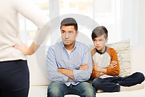 Upset or displeased father, son and mother at home