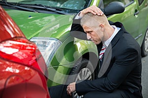 Upset driver looking at car after traffic collision