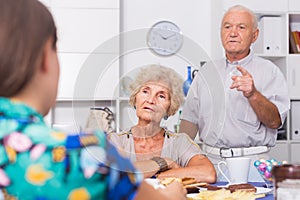 Upset elderly pair having tough talk with girl