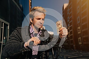 An upset European man holds a small salary of a banknote. concept of a businessman who lost his job