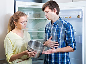 Upset family couple looking at empty shelves