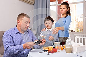 Upset father giving money to wife and son