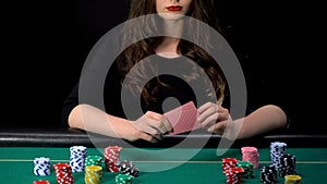 Upset female gamer losing poker round, bad hand, casino chips on table around