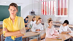 Upset female student standing in classroom