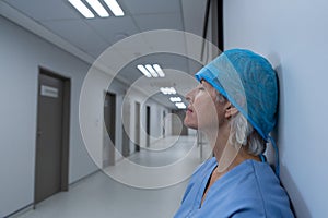 Upset female surgeon sitting in the corridor of hospital