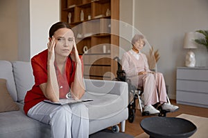 Upset frustrated doctor holding head leaned over patient card