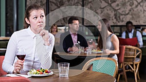 Upset girl dining alone in restaurant