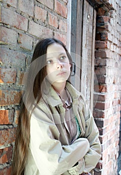 Upset girl near brick wall