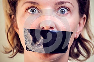 Upset girl with self-adhesive tape over her mouth. Kidnapping concept