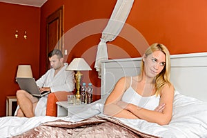 Upset girl sitting bed after fight boyfriend photo