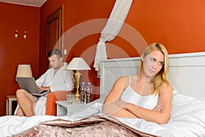 Upset girl sitting bed after fight boyfriend