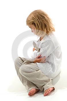 Upset Girl Sitting on the Floor with Her Knees Up and Folded Hands.