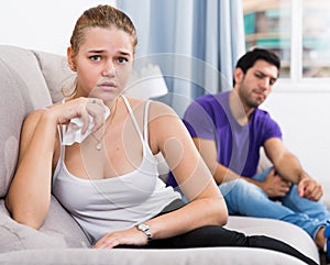 Upset girl on sofa after quarrel with husband