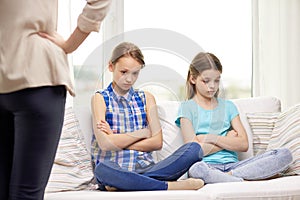 Upset guilty little girls sitting on sofa at home photo