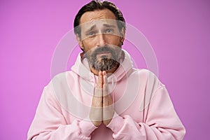 Upset handsome bearded mature man need help asking forgiveness supplicating press palms together praying frowning sorrow
