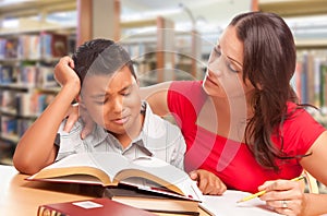 Upset Hispanic Young Boy and Famle Adult Studying At Library