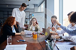 Upset leader of business team sit full of sadness on table with co-workers