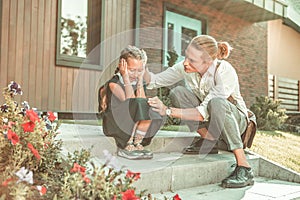 Upset little girl in black school uniform desperately crying