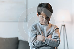 Upset little kid boy with arms crossed