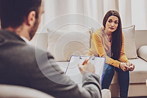 Upset longhaired girl talking with psychiatrist