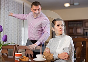 Upset man and frustrated woman arguing at home