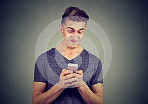 Upset man holding cellphone disgusted with message he received