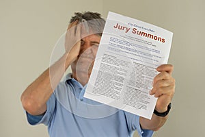 Upset man holding jury duty summons received in the mail photo