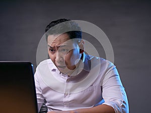 Upset Man Looking at Laptop