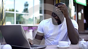 Upset man looking at laptop, disappointed with lost funding for start up, fail