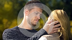 Upset man looking at woman and touching her face, lack of money, unemployment