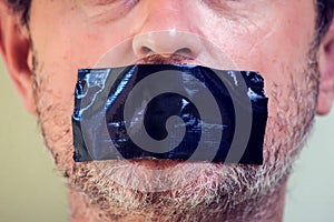 Upset man with self-adhesive tape over her mouth. Kidnapping concept