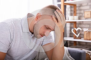 Upset Man Sitting On Sofa