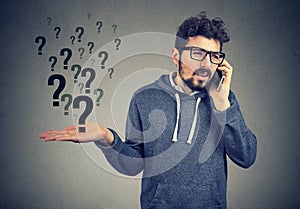 Upset man talking on mobile phone has many questions