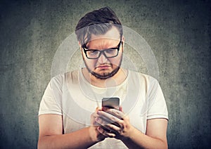 Upset man watching at smartphone