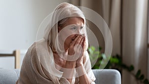 Upset mature woman crying, sitting alone, feeling lonely and unwell