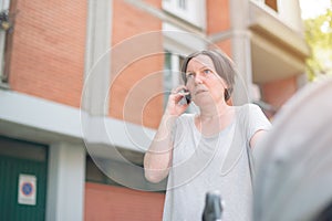 Upset mother talking on mobile phone