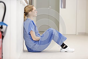 Upset nurse sitting on floor