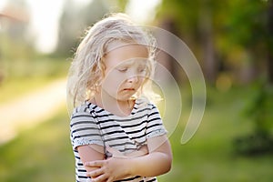 Upset or offended little girl standing on street of small town`s or village`s. ÃÂ¡risis of three years