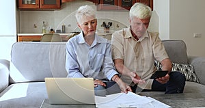 Upset older couple calculates expenses looking stressed