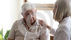 Upset older man listening to supportive speech of pleasant doctor.
