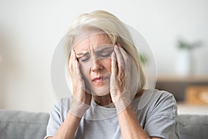 Upset older woman touching temples aching head feeling strong he
