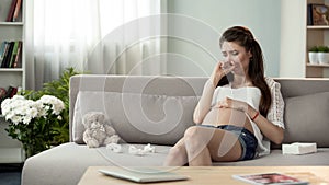 Upset pregnant lady crying on sofa, hormonal disorder emotional problems