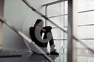 Upset preteen boy sitting on staircase