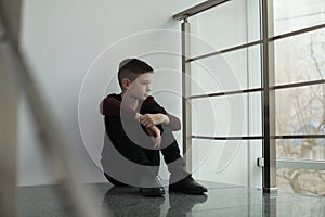 Upset preteen boy sitting on staircase