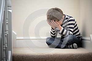Upset problem child sitting on staircase photo