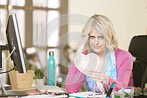 Upset Woman in her Office with a Valentine Heart