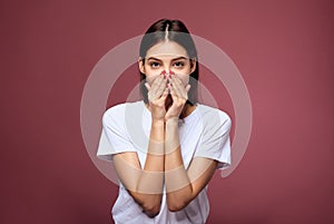 A upset sad brunette covers her face with her hands
