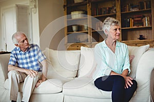 Upset senior couple relaxing on sofa