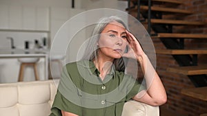 Upset senior gray-haired Asian woman has a feelings of severe despondency