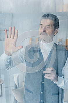 Upset senior man waving hand while